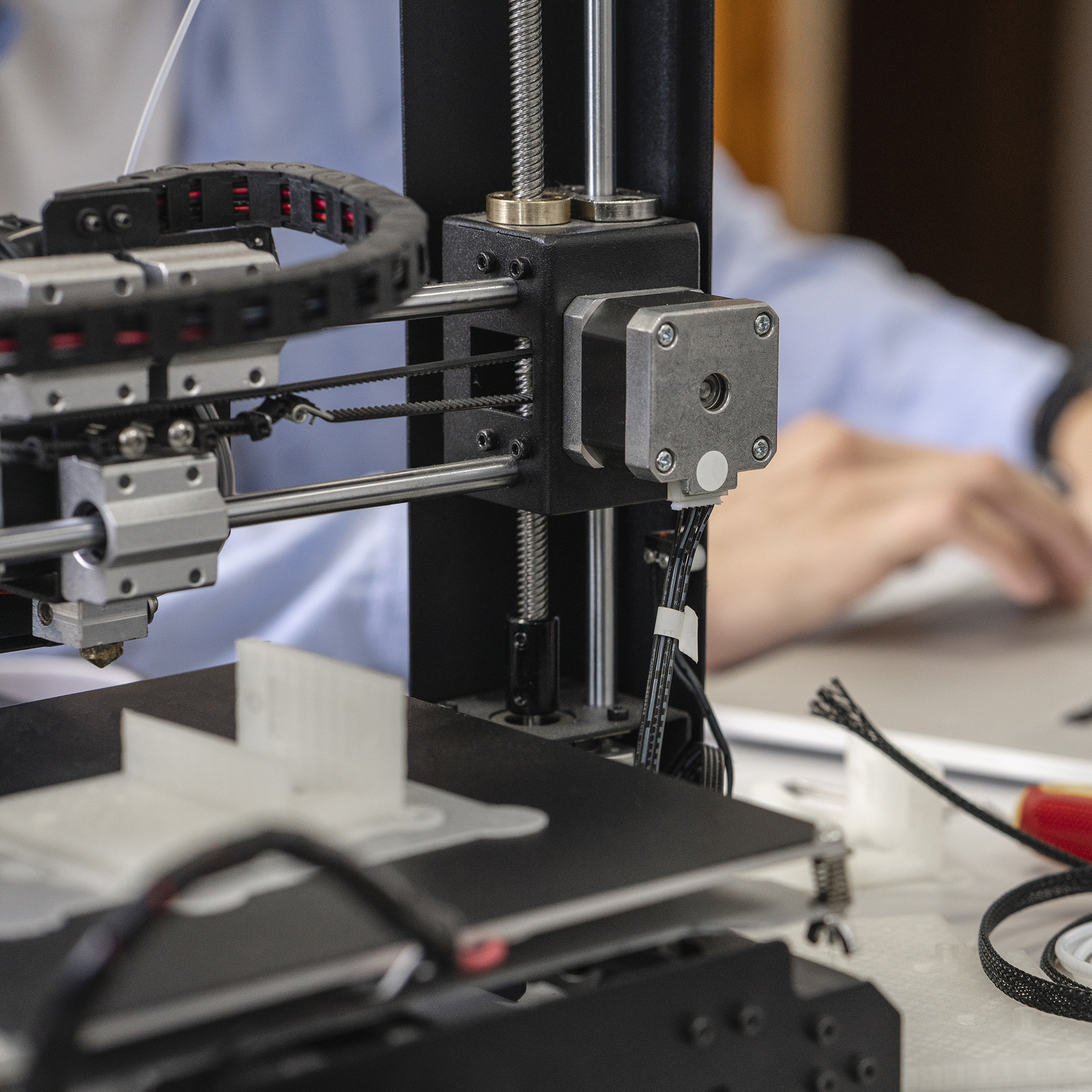 Student setting up 3D printer,using laptop,  close up